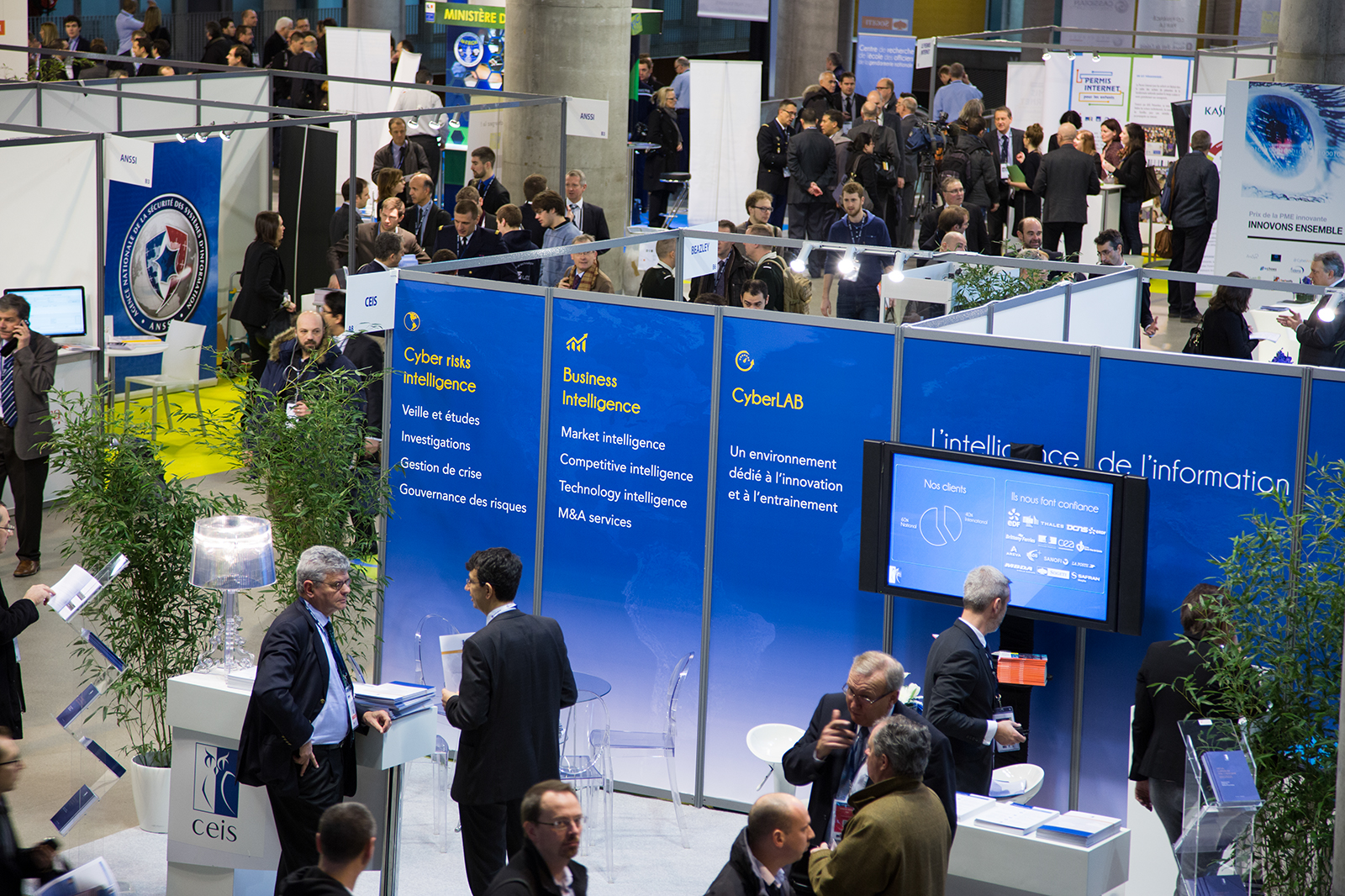 Vue plongée du salon FIC 2014 avec stands Cyber Risks Intelligence et public en networking — reportage conférence corporate à Paris